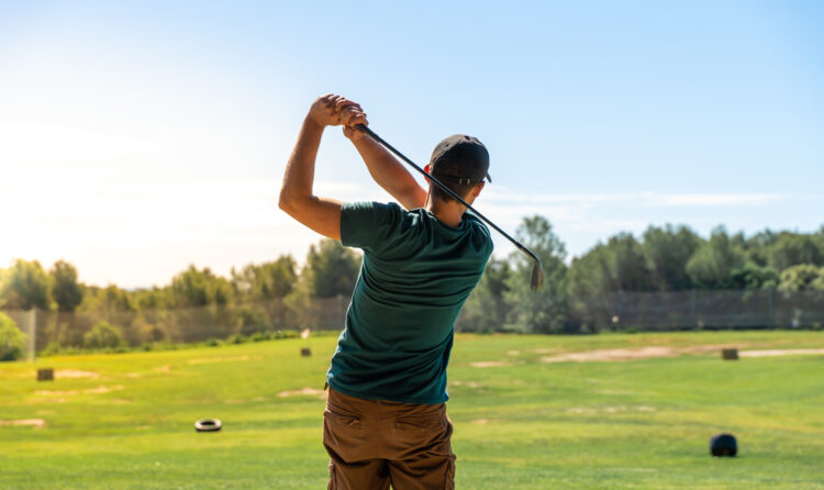 Golf hit in a wide golf course in summer. Young male playing. High quality photo